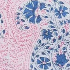 A close-up of a paisley patterned fabric swatch featuring intricate floral and teardrop motifs in blue and pink on a white background.