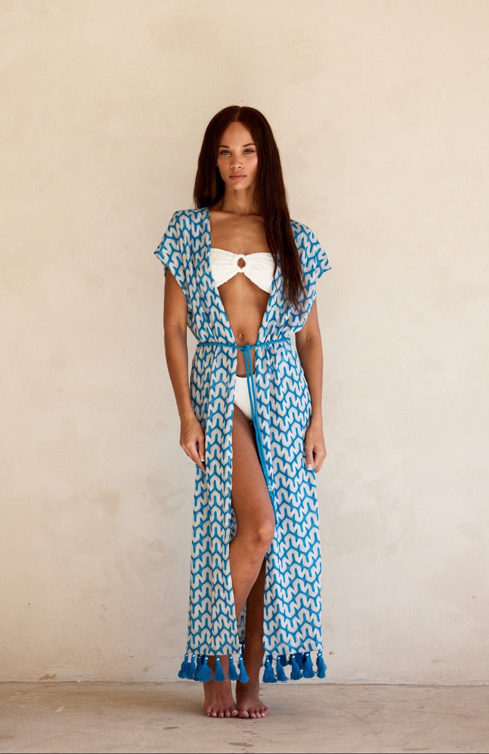 Woman wearing the Noni Kimono in Sapphire by BTB Los Angeles for a chic beach day look.