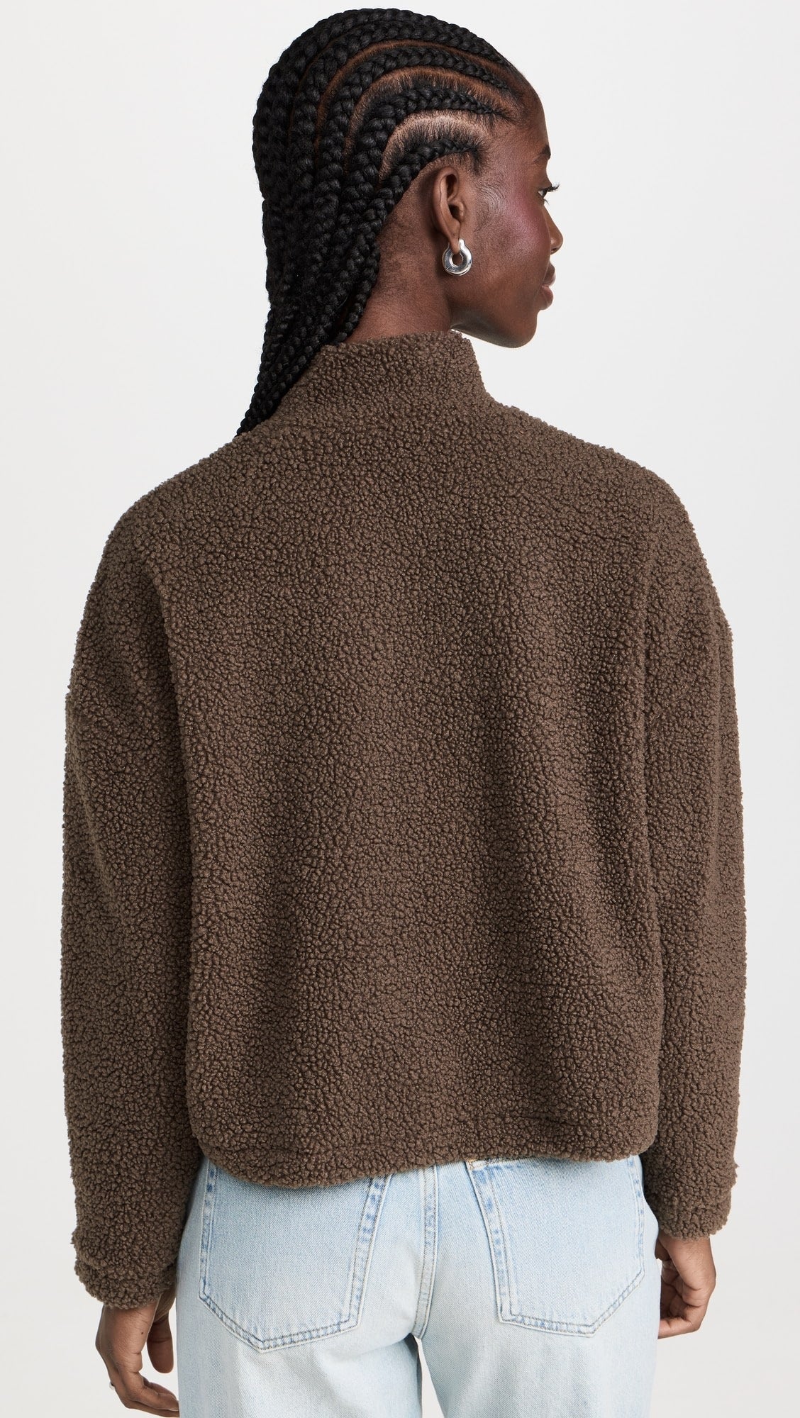 Rear view of a model wearing the LNA Sherpa half-zip in brown sherpa styled light wash jeans.