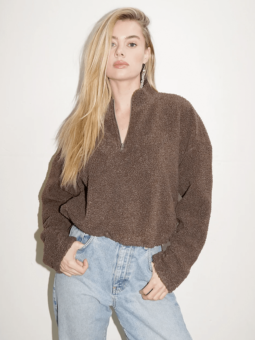 LNA sherpa half zip in brown cinched and styled on a blonde model with high-rise, light wash jeans.