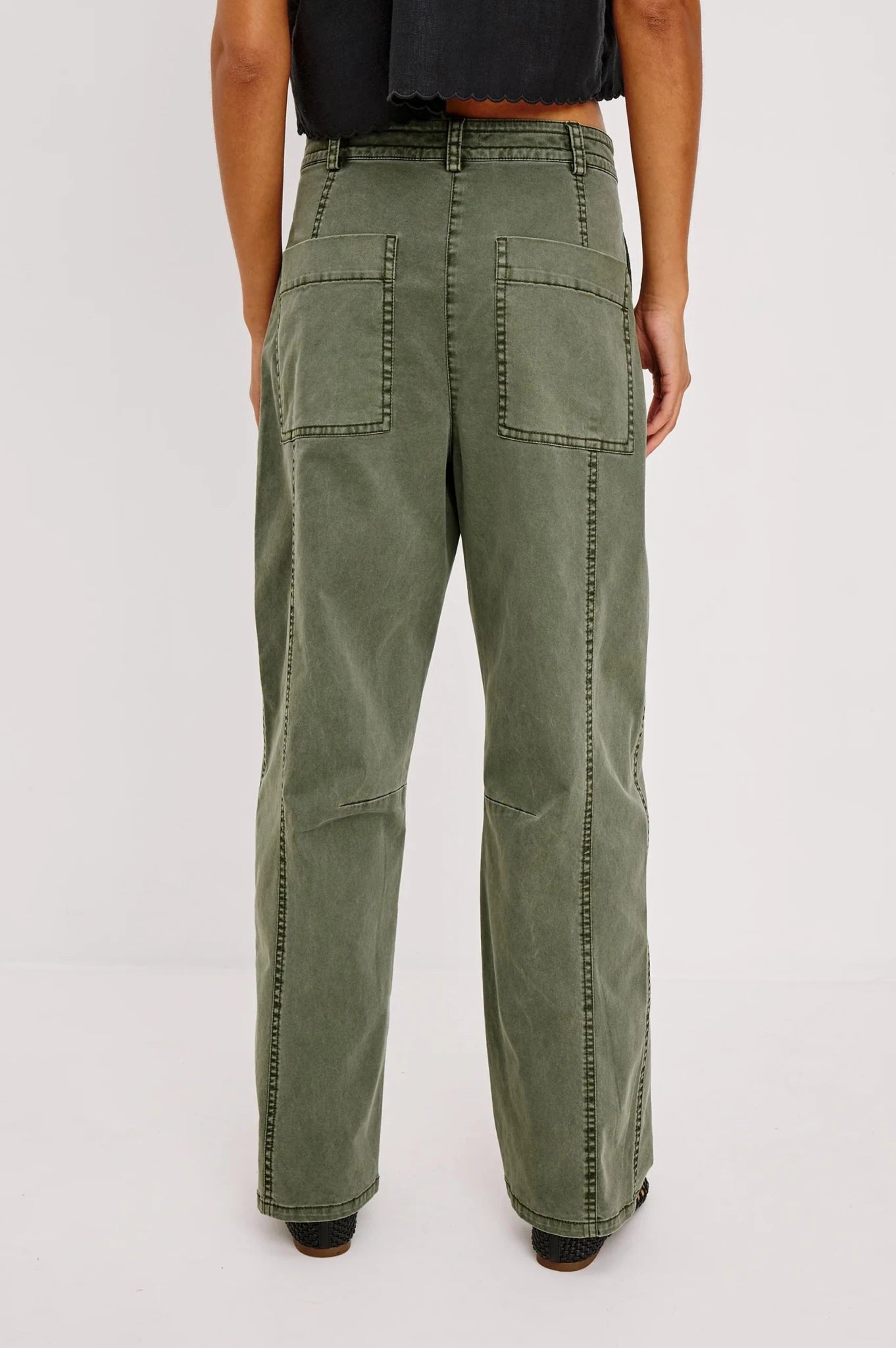 Rear view of a woman modeling the Rails Lunar pants in Military Olive showing off the oversized cargo pockets and seam-work.