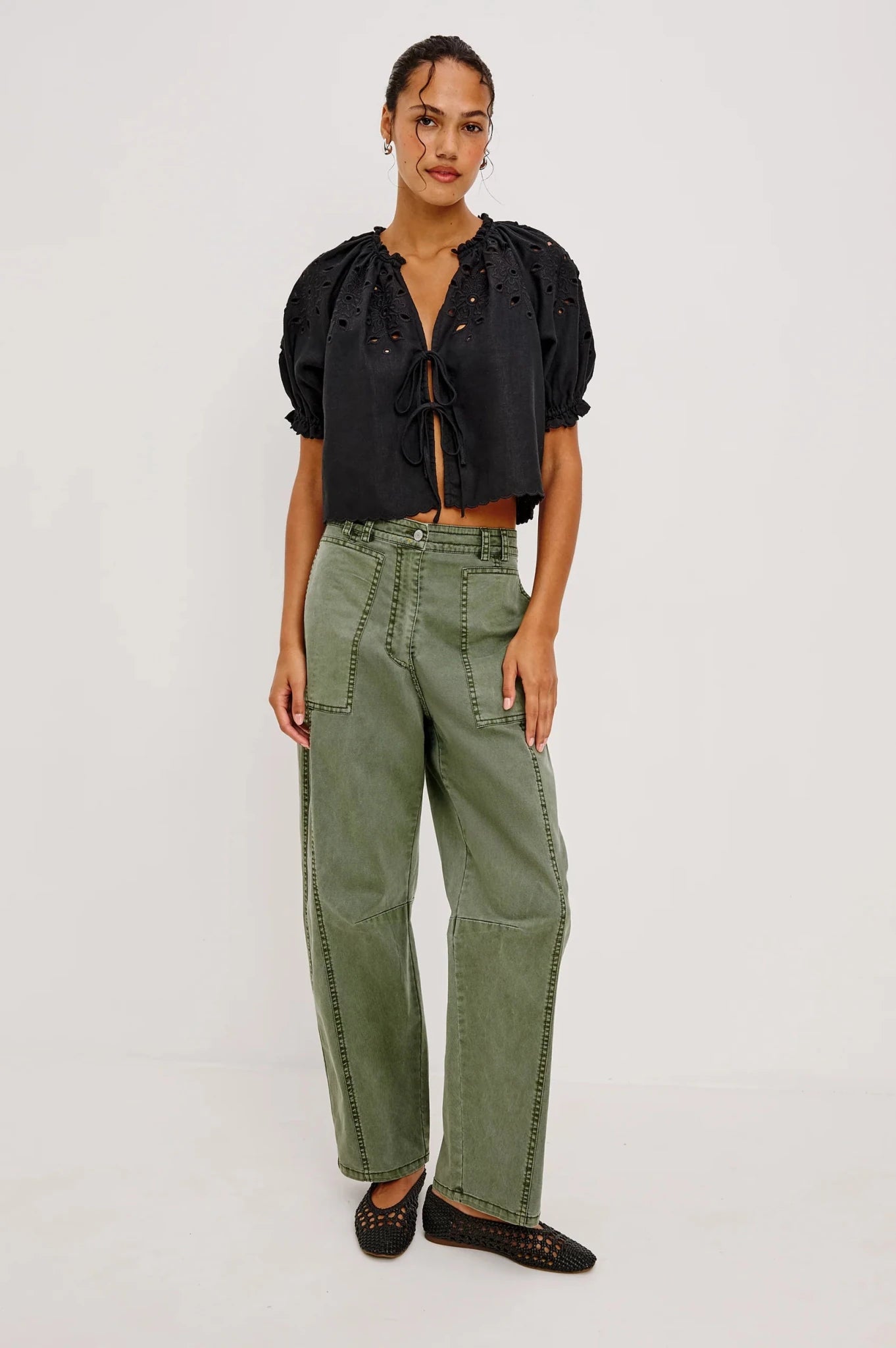 Woman modeling the Rails Lunar Pants in Military Olive worn with a black blouse and shoes.