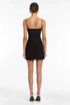 Rear view of a woman wearing the Amanda Uprichard Isabel Mini Dress with heels