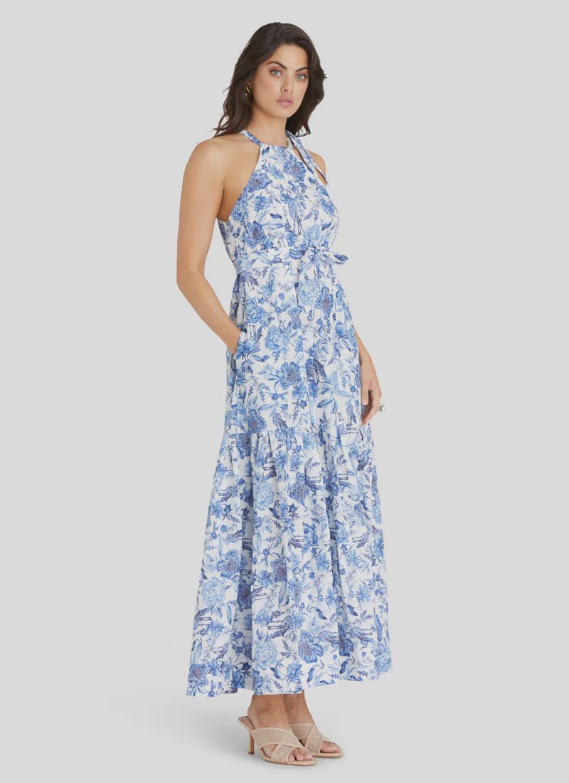 Model wearing Aqua Blu Australia Azalea Zoe Dress in blue floral print with halter neckline and maxi skirt.