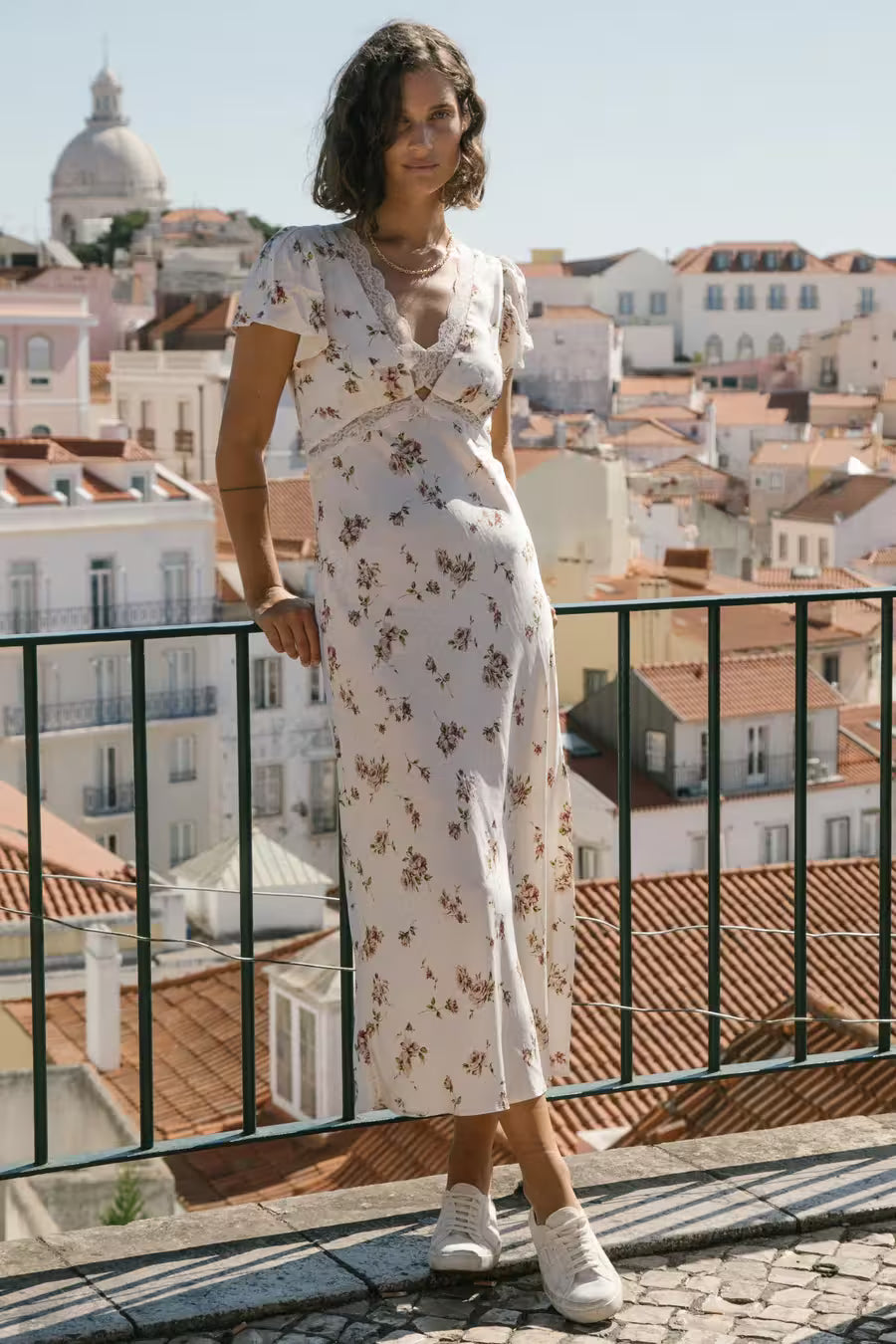 Auguste the Label Rianne Midi Dress in a white floral print, styled as an everyday spring outfit with white sneakers.