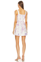 Back view of LoveShackFancy Lowery Mini Dress in Spanish Lilac showing the smocked bodice and ruffled A-line skirt.