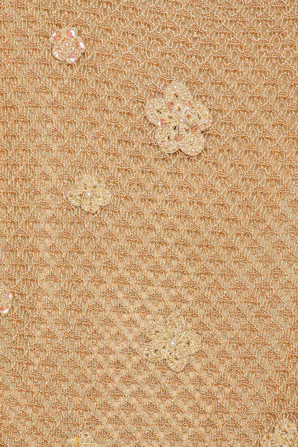 Close-up detail of LoveShackFancy Vreya dress showing hand-crocheted flowers, metallic gold yarn, and delicate sequin embroidery.