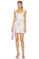 LoveShackFancy Lowery Mini Dress in Spanish Lilac featuring a floral print, corset bodice, and ruffled A-line skirt.