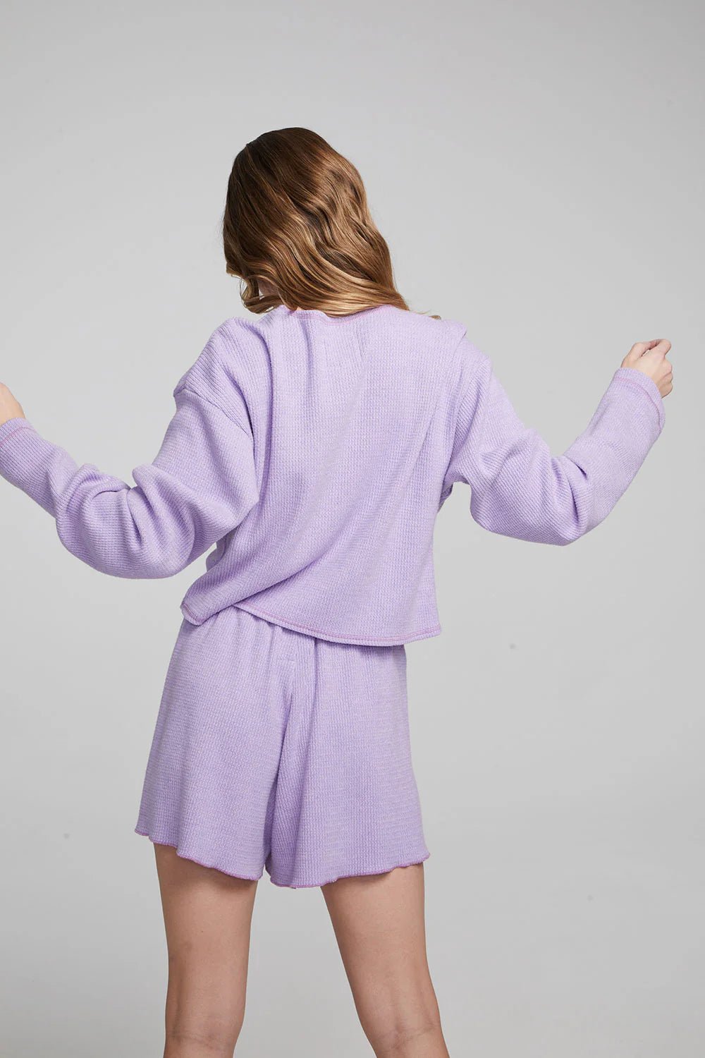 Back view of a woman wearing the Digital Lavender Chaser thermal lounge set with long sleeve top and matching shorts.