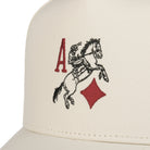 Front view of the Brixton Aces men's snapback hat in off-white organic cotton, featuring a high-profile crown and red and black playing card embroidery.