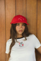 Lifestyle shot of the red Brixton Running On Empty hat featuring white fuel gauge embroidery and a structured 6-panel cotton design.