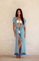 Woman wearing the Noni Kimono in Sapphire by BTB Los Angeles for a chic beach day look. 