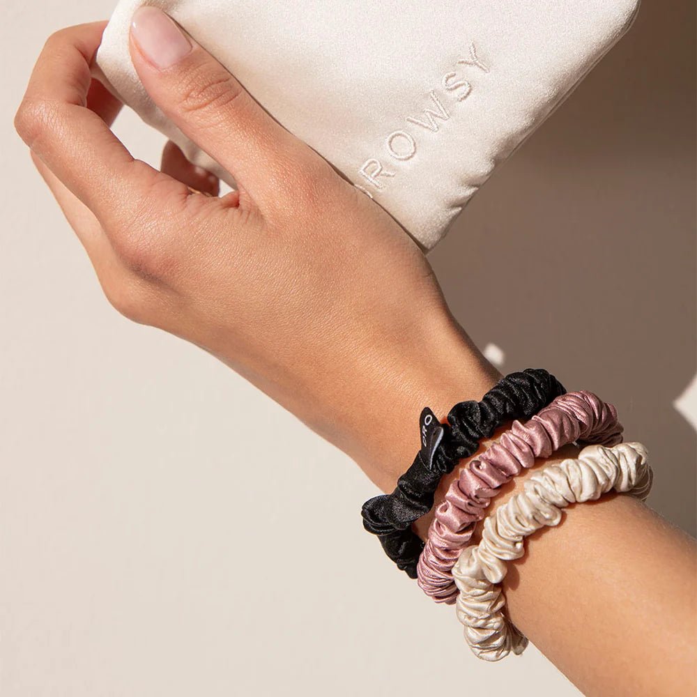 Drowsy silk scrunchies on a wrist.