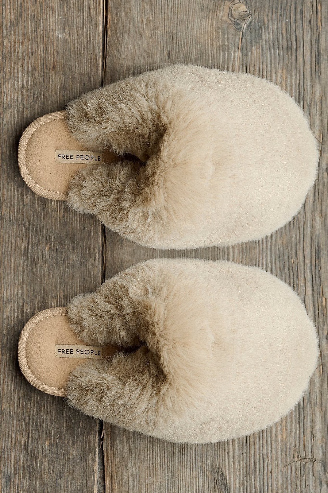 Free People Snowball Slippers on a wood surface