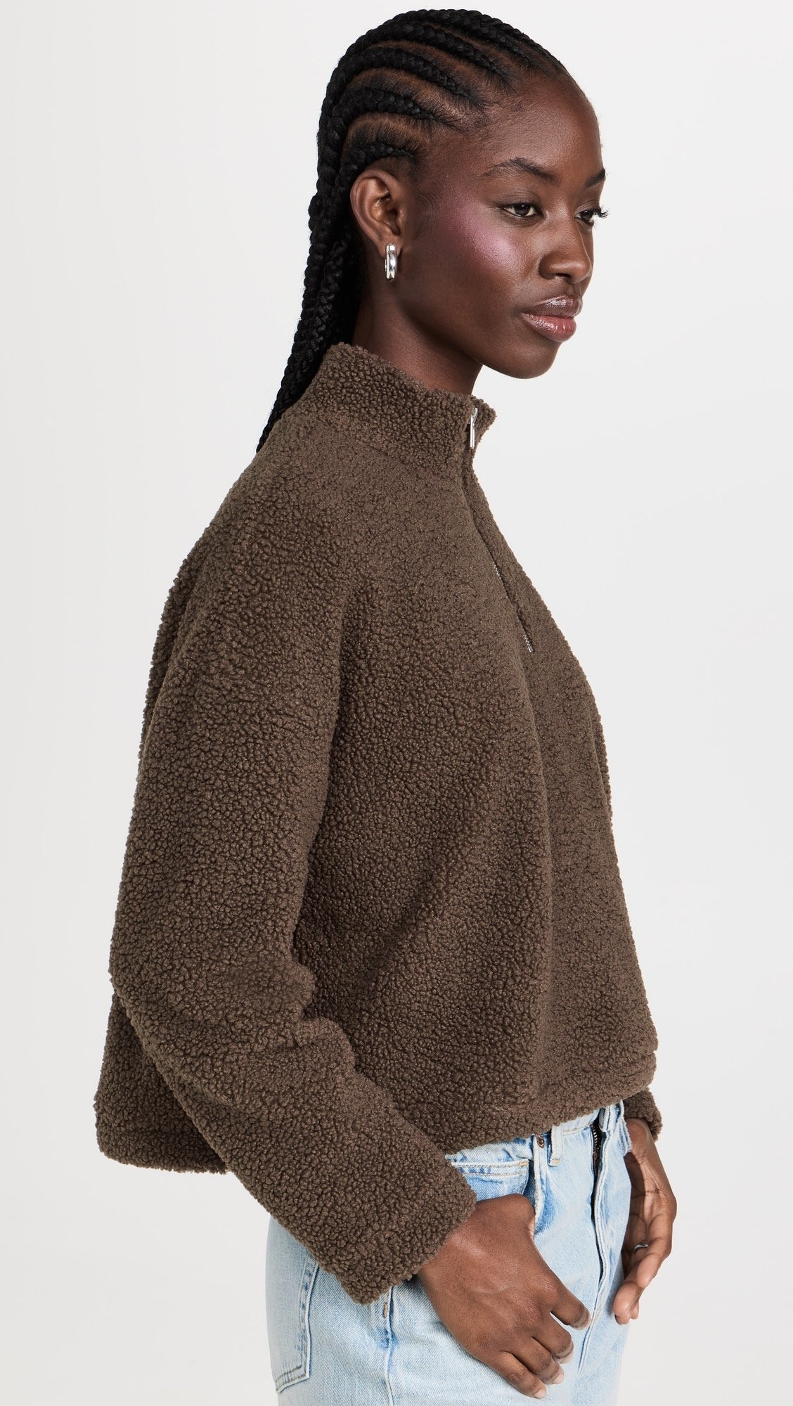Side profile of a model wearing the LNA Sherpa half-zip in brown sherpa styled light wash jeans.