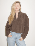 LNA sherpa half zip in brown cinched and styled on a blonde model with high-rise, light wash jeans.