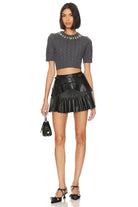 Model wearing the LoveShackFancy Chapelle Crop Top in grey with the LoveShackFancy Eli Vegan Leather Mini Skirt in black.