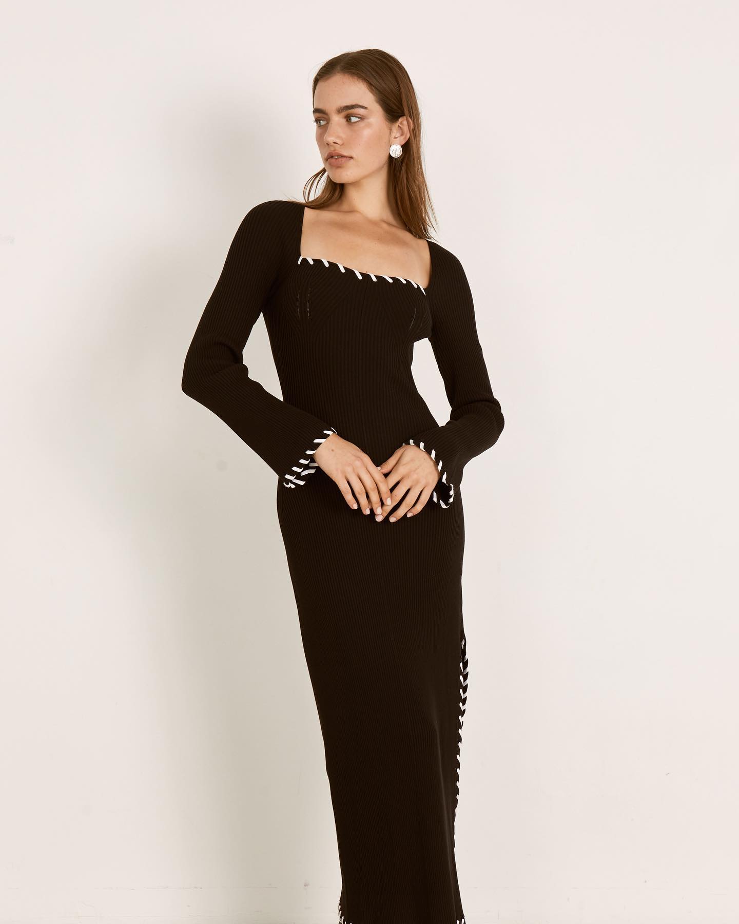 Full-length view of the black Mon Renn Trace Knit Midi Dress featuring a square neckline, long sleeves with white contrast stitching, and a side slit - Endless Waves.