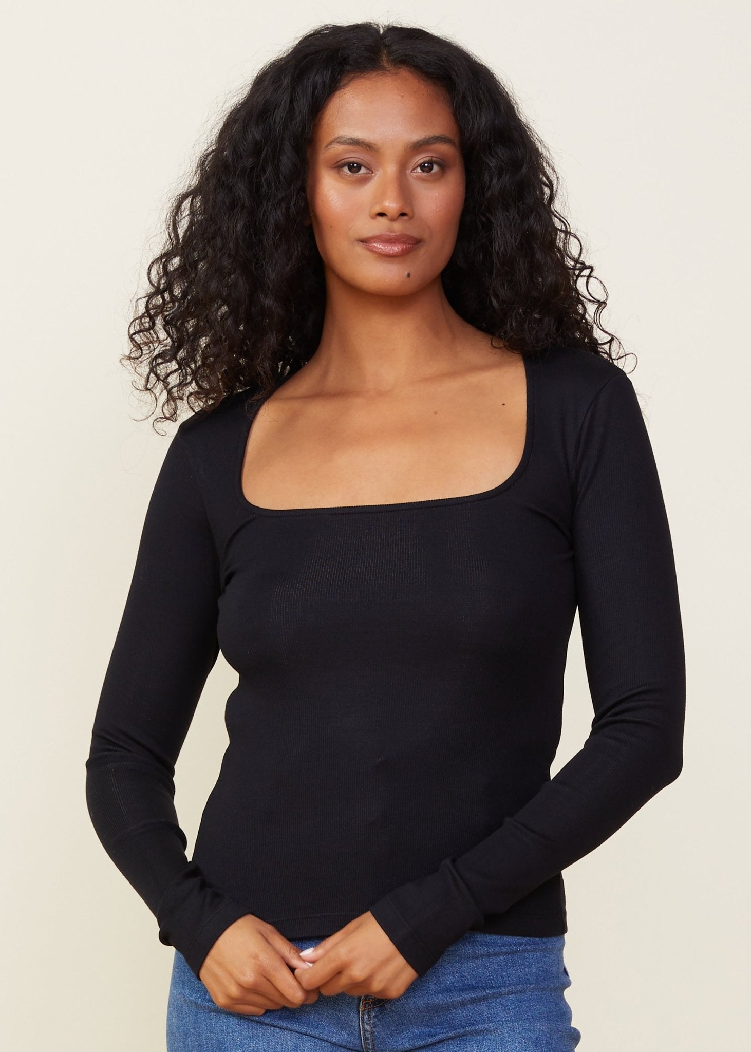 Woman wearing the Monrow 90's ribbed long sleeve squarer neck top with denim.