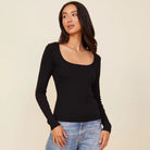 Woman wearing the Monrow square neck 90s rib long sleeve in black with denim.