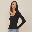 A woman wearing the Monrow 90's Rib Long Sleeve top with a square neckline.