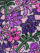 Detailed texture shot of hand-embroidered floral motif on a luxury purple swimsuit by Oceanus, featuring sparkling beadwork.